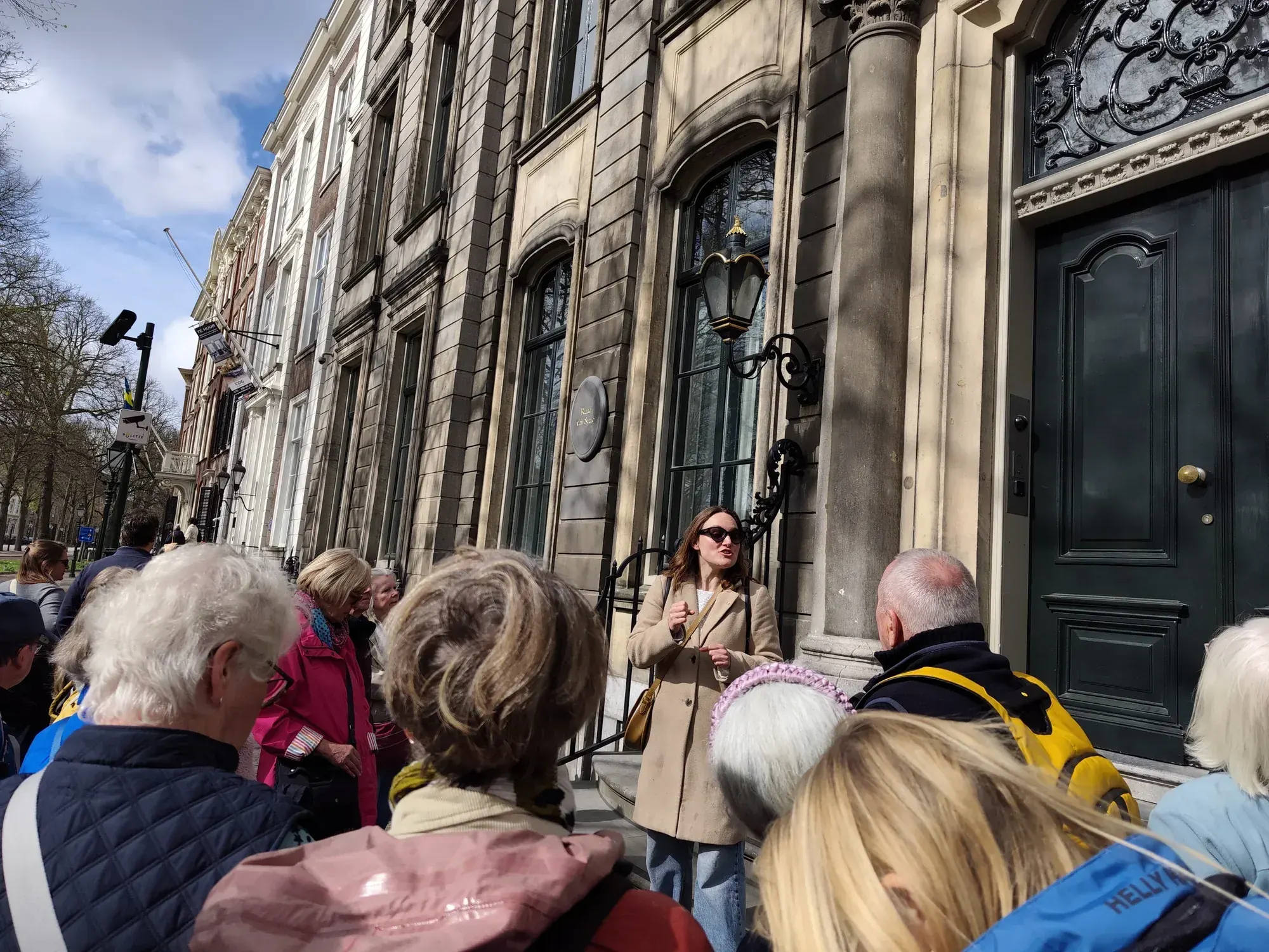A guide and private tour group in front of a historic facade in the centre of The Hague