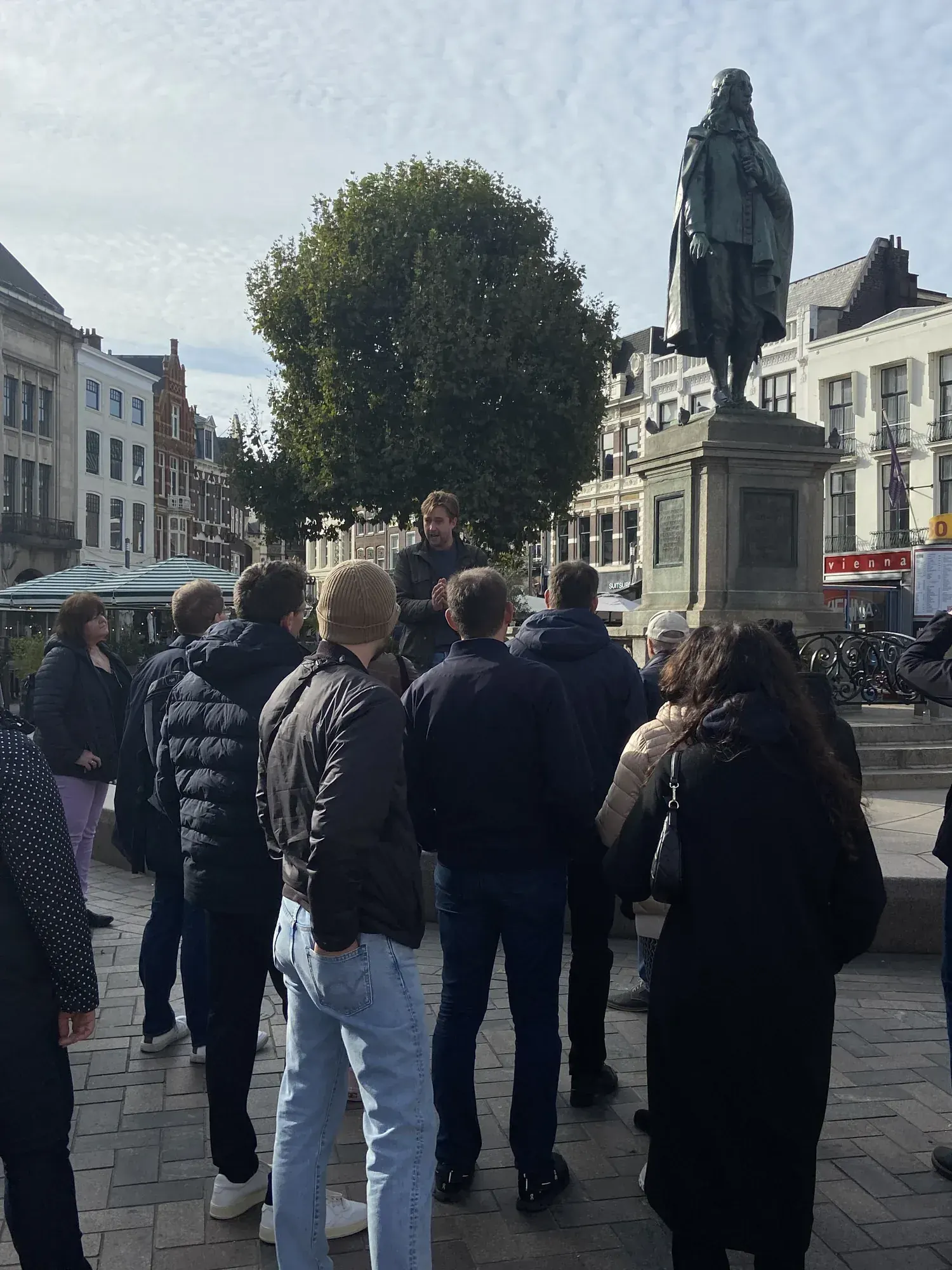 A guide and tour group at the Johan de Witt statue on Plein during a walking lunch in The Hague