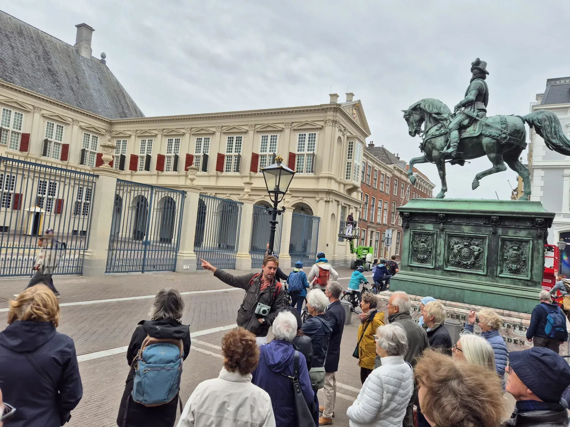 A guide with a group in front of Noordeinde Palace