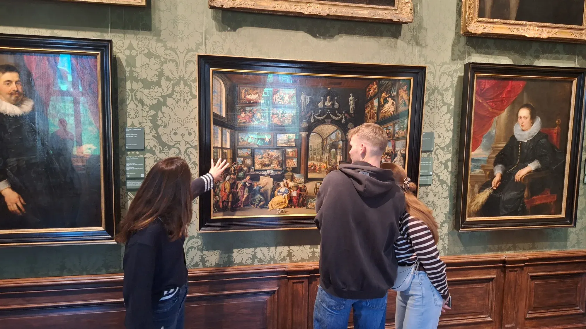 Een privégroep bekijkt een geschilderd galerij-interieur in het Mauritshuis tijdens de rondleiding