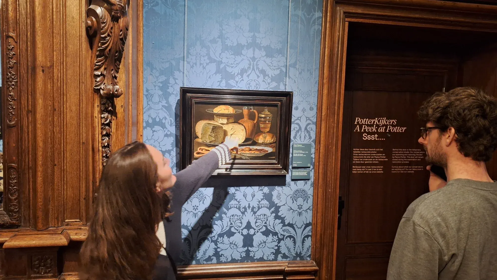 Een gids wijst details aan in het stilleven met kazen van Clara Peeters, Mauritshuis