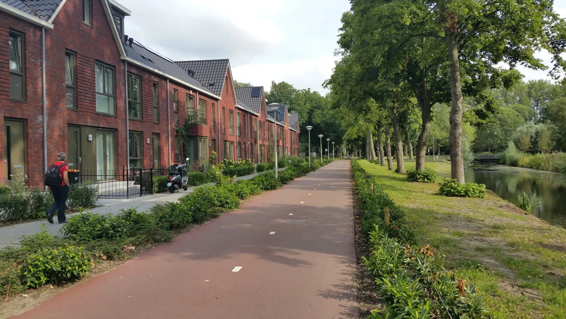 A red cycle path along the water in The Hague