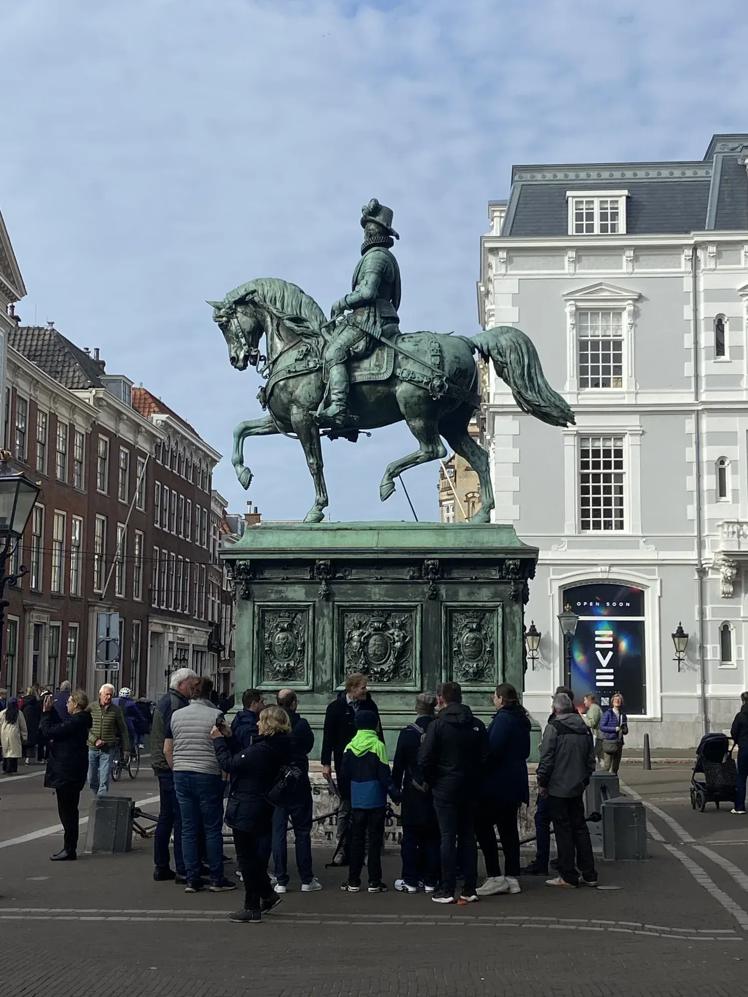 Eine Gruppe am Reiterstandbild Wilhelms von Oranien vor dem Paleis Noordeinde in Den Haag